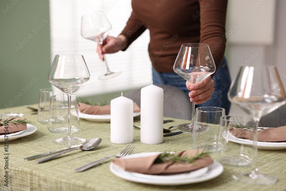 Young woman setting table for dinner at home, closeup Young woman setting table for dinner at home, closeup