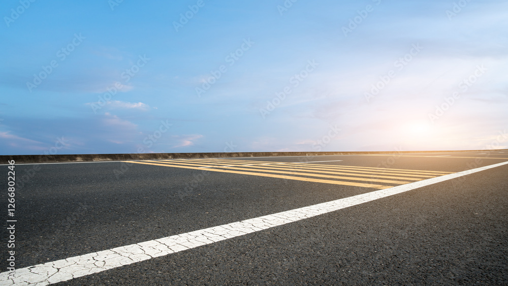 Fototapeta premium Serene Sunset Over an Empty Road with Yellow and White Lines