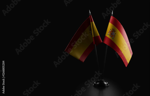 Small national flag of the Spain on a black background photo