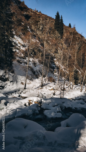 beautiful winter mountains scenery with hight rocks, cold river and sunshine weather