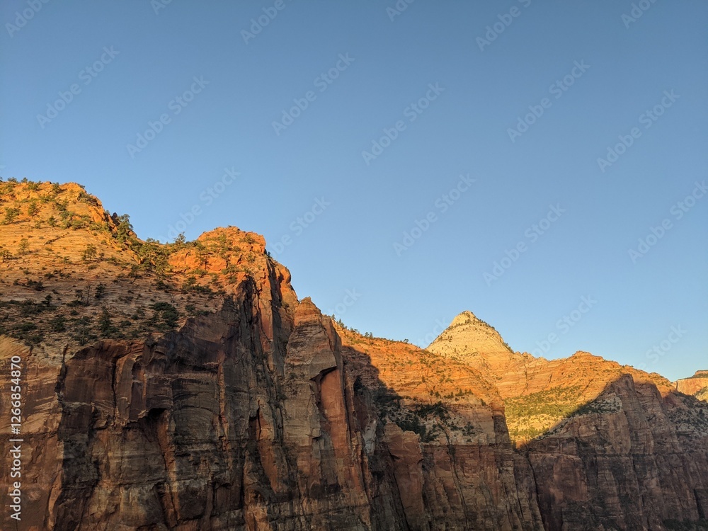 Sunrise Over Zion Canyon with Golden Light Flowing Through the Canyon Walls, Various Greenery of Early Spring May Landscape, and River Below Sunrise Over Zion Canyon with Golden Light Flowing Through the Canyon Walls, Various Greenery of Early Spring May Landscape, and River Below
