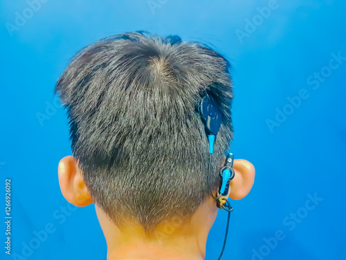 Obraz na plátne Child use a cochlea implant , therapy, hearing, behind the ear, Cochlea implant system
