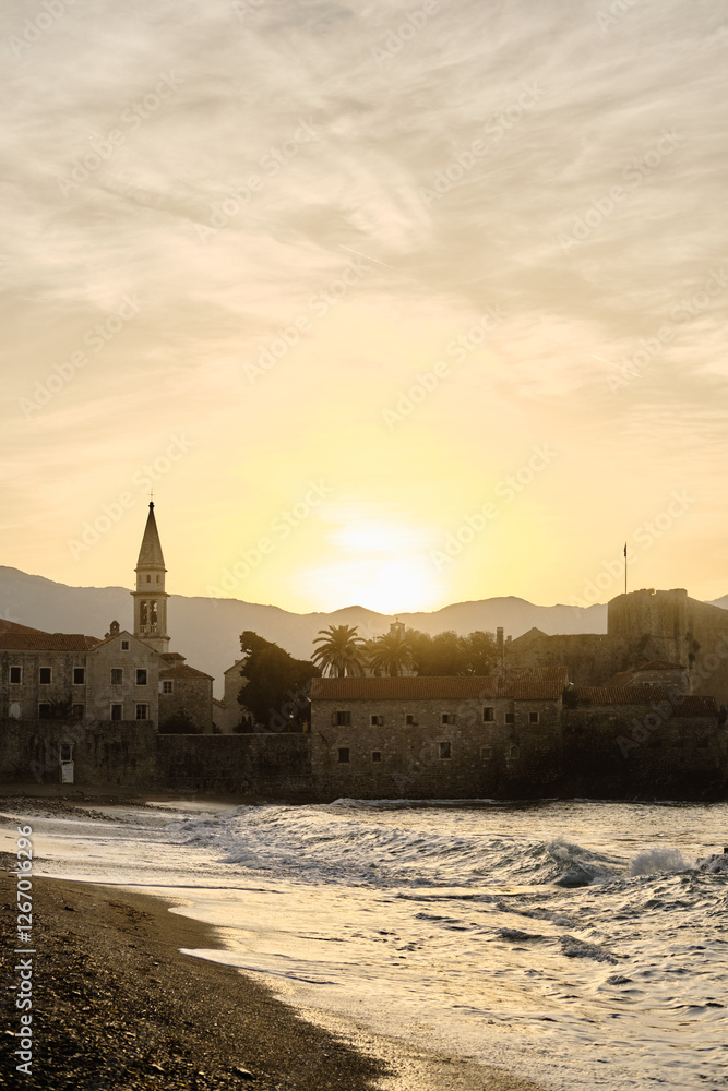 Fototapeta premium View of the old town with fortress and citadel at dawn. The coast of the Adriatic Sea. Budva, Montenegro in the morning sun.