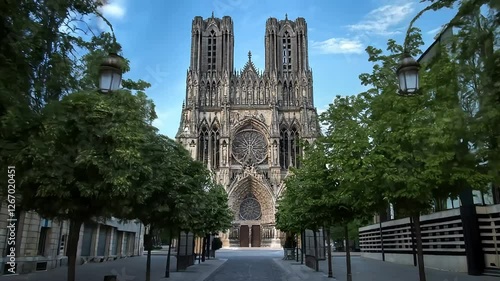Cathedral architecture in a quiet street with trees in Reims during daylight hours