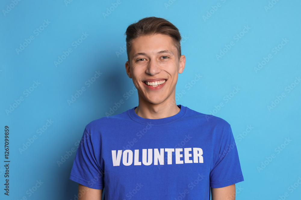 Portrait of smiling volunteer on light blue background Portrait of smiling volunteer on light blue background