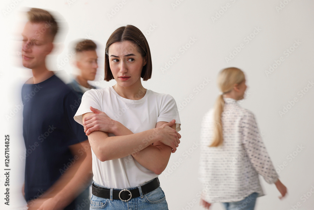 Young woman feeling uncomfortable among people indoors Young woman feeling uncomfortable among people indoors