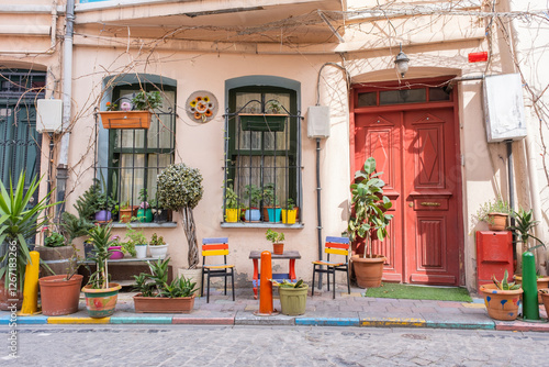 Colorful popular street corner scene in Balat neighborhood, Istanbul. Lively housefront, potted plants, red door and chairs. Popular tourist attraction. Vibrant street with plants and painted details