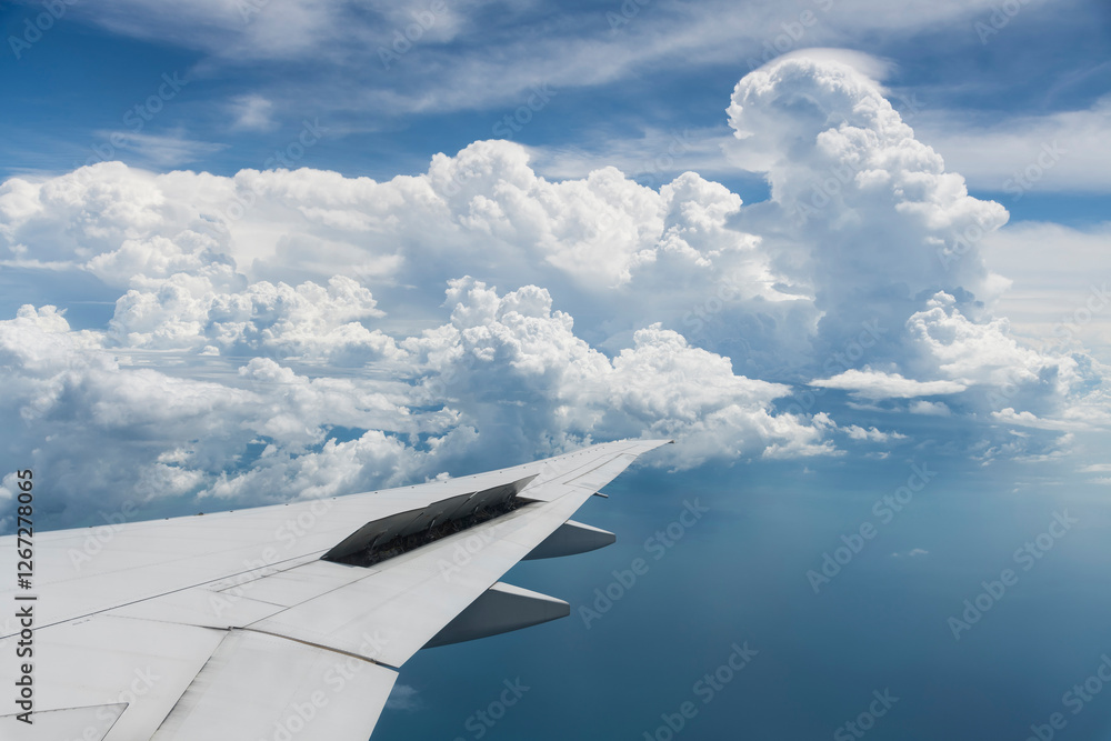 Fototapeta premium View of the plane's wing and beautiful clouds through the window during the flight.