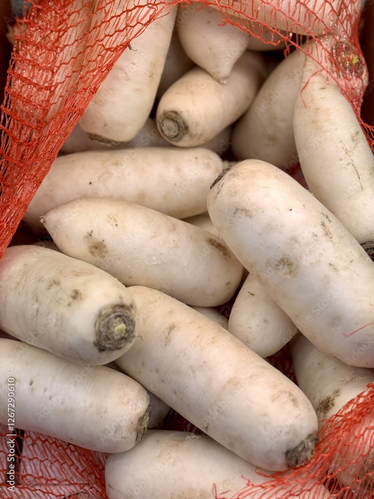 A lot of fresh organic large white radishes in the box on sale in vegetable stand display at supermarket shop organic food, vegetarian food, healthy food A lot of fresh organic large white radishes in the box on sale in vegetable stand display at supermarket shop organic food, vegetarian food, healthy food
