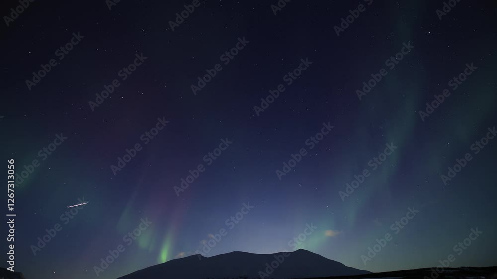 Breathtaking time-lapse of the Aurora Borealis dancing across the dark sky over the mountains in Northern Norway, in the Tromsø region. A horizontal 4K video Breathtaking time-lapse of the Aurora Borealis dancing across the dark sky over the mountains in Northern Norway, in the Tromsø region. A horizontal 4K video
