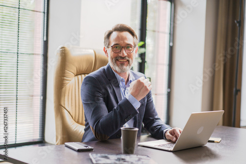 A confident businessman working remotely in a modern office, focused on his career goals