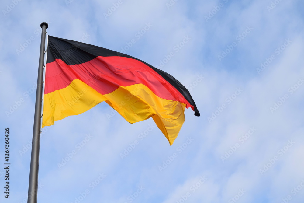 The German Unity Flag is a national memorial to German reunification that was raised on 3 October 1990. It flies in front of the Reichstag building in Berlin (seat of the German parliament). The German Unity Flag is a national memorial to German reunification that was raised on 3 October 1990. It flies in front of the Reichstag building in Berlin (seat of the German parliament).