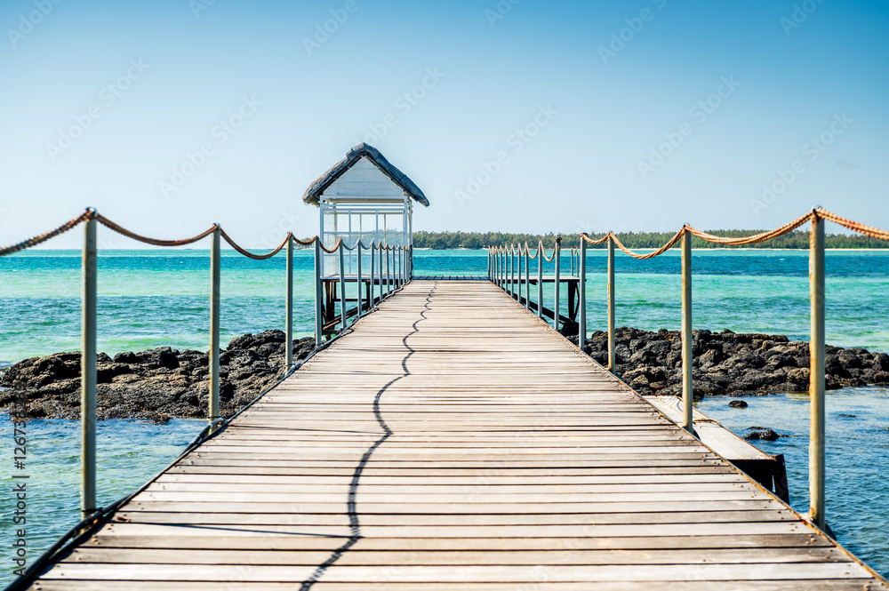 Fototapeta premium Gros plan sur un ponton et une petite cabane menant vers une mer tropicale turquoise, île Maurice 