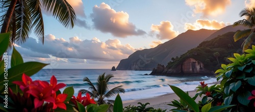 Obraz na płótnie Tropical beach cove at sunset with red flowers in the foreground, palm trees, and dramatic cliffs overlooking the ocean w salonie