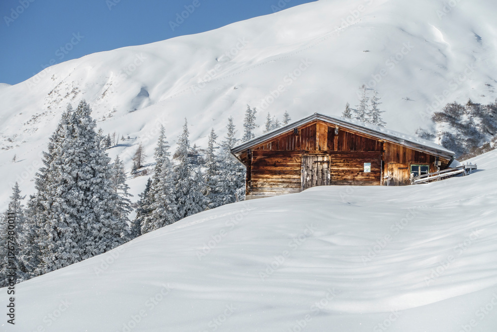 herrliche Winterlandschaft mit Schihütte in den verschneiten Bergen von Tirol Österreich