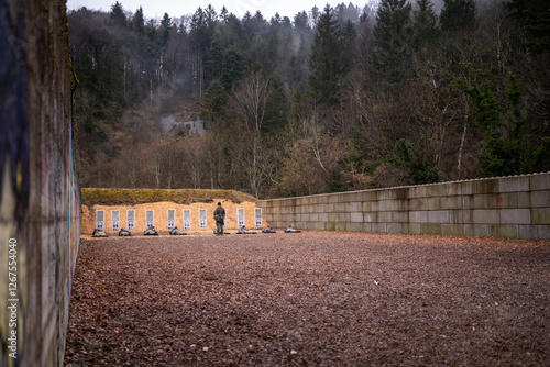 un militaire debout contrôle le bon déroulement du tir en KD-Box à l'armée suisse, tireurs position de tir couché allongé. photo