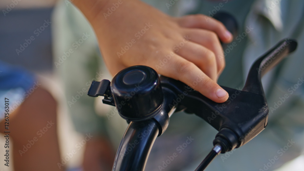 Kid hands touching bicycle outdoors closeup. Small boy preparing to bike ride Kid hands touching bicycle outdoors closeup. Small boy preparing to bike ride