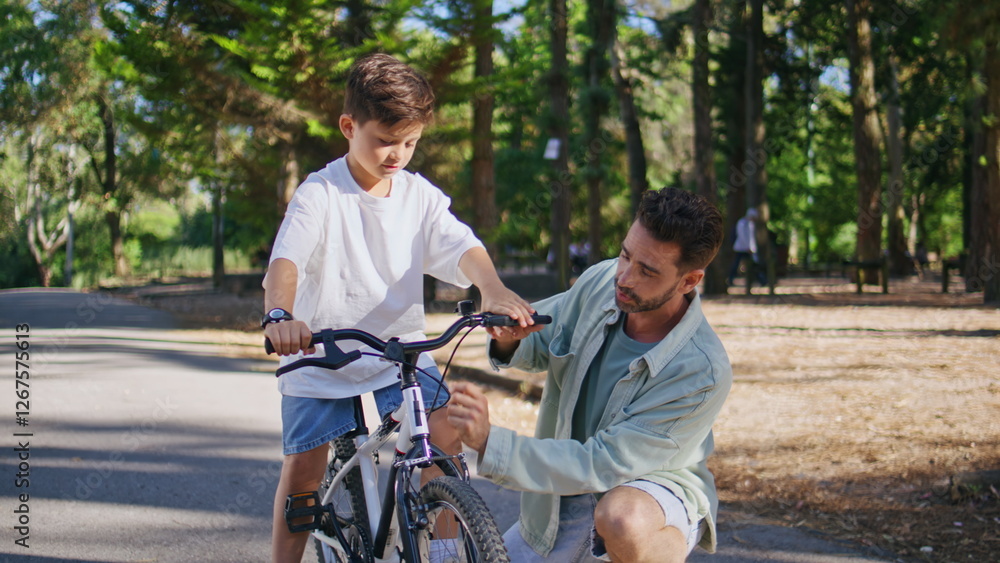 Daddy explaining child cycling in autumn park closeup. Kid learning ride bike Daddy explaining child cycling in autumn park closeup. Kid learning ride bike