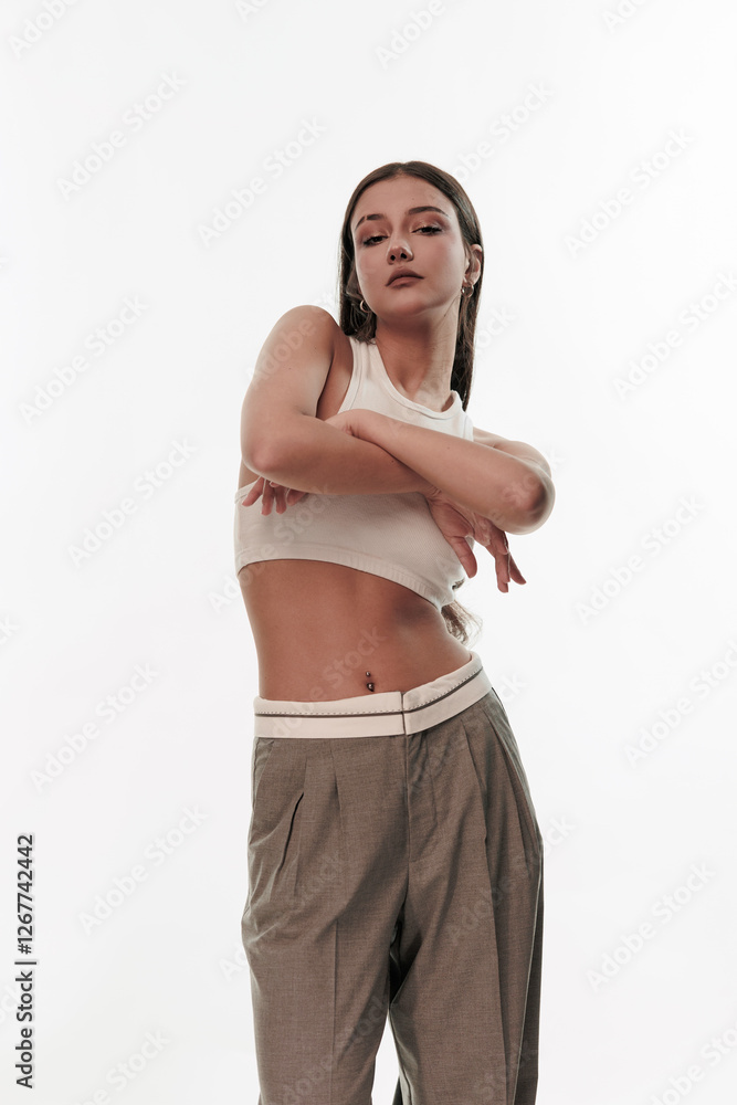 Fototapeta premium Young girl in trousers posing on a white background