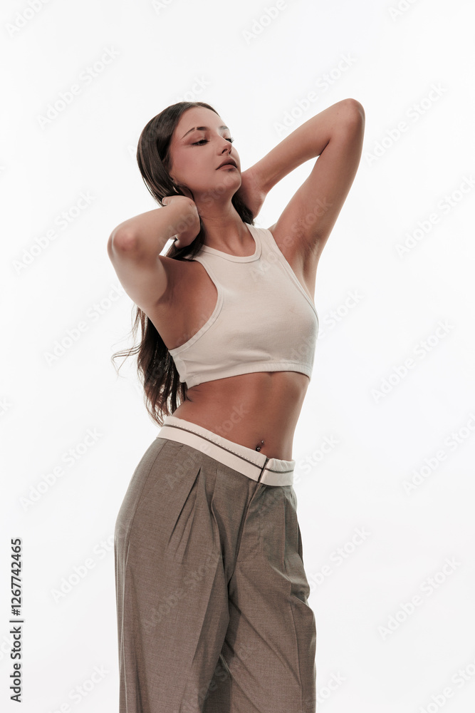 Young girl in trousers posing on a white background Young girl in trousers posing on a white background