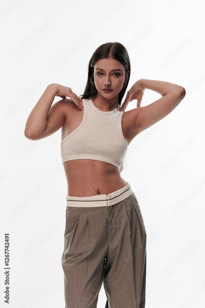Fototapeta premium Young girl in trousers posing on a white background