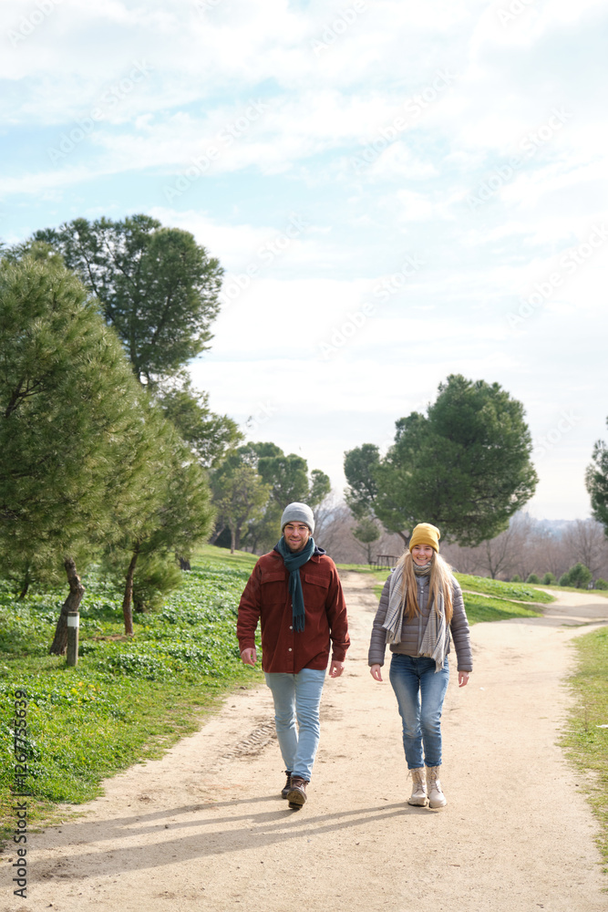 Fototapeta premium Happy couple wearing winter clothes walking in a park