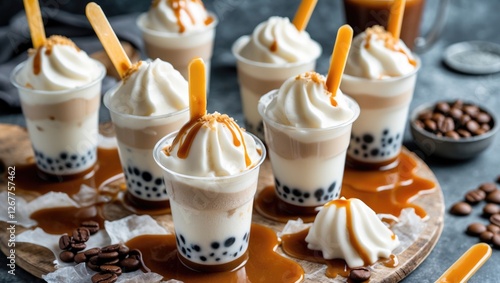 Dessert cups with creamy layers topped with whipped cream and caramel sauce served on a wooden platter with coffee beans and copy space photo