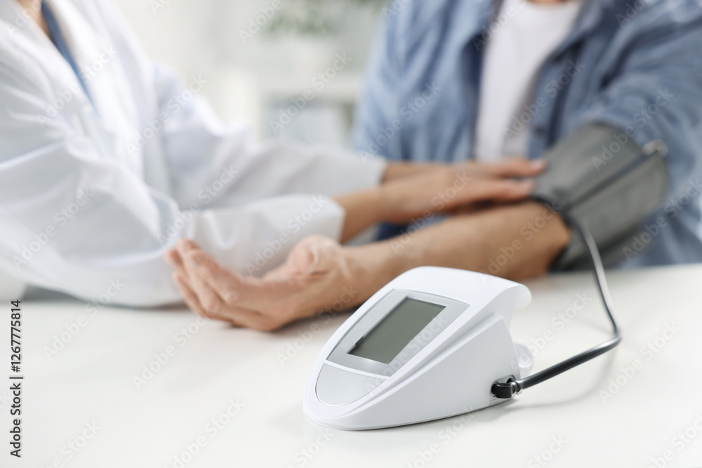 Doctor measuring senior man's blood pressure during appointment in hospital, closeup Doctor measuring senior man's blood pressure during appointment in hospital, closeup