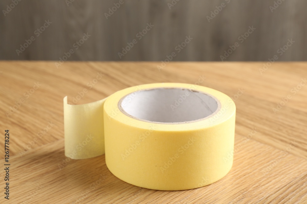 One adhesive tape on wooden table, closeup One adhesive tape on wooden table, closeup
