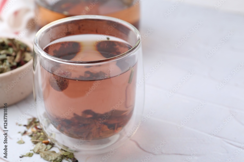 Delicious herbal tea and dry leaves on white table, closeup. Space for text Delicious herbal tea and dry leaves on white table, closeup. Space for text