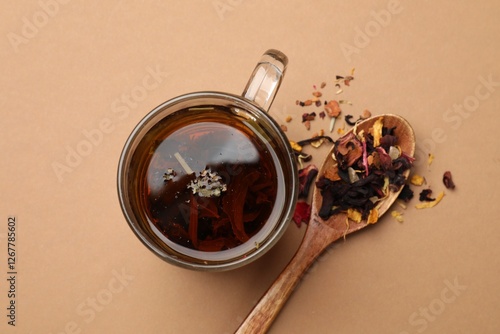 Tableau sur toile Aromatic tea and dried leaves on brown background, flat lay