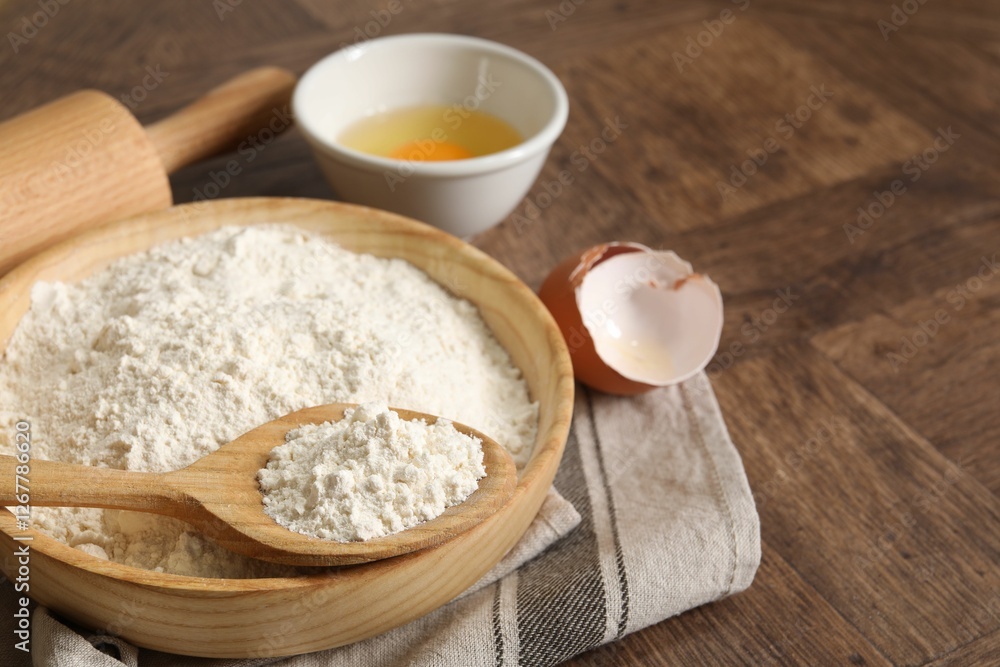 Rolling pin, flour and yolk on wooden table, closeup. Space for text Rolling pin, flour and yolk on wooden table, closeup. Space for text
