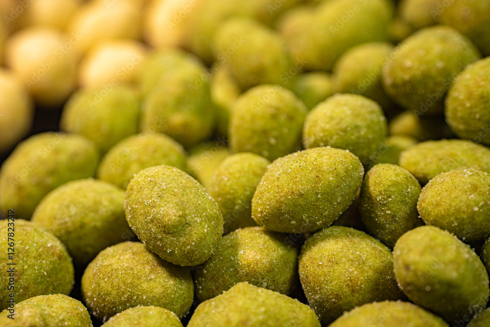 A detailed close-up of two varieties of peanuts, one with a green spice and the other with a yellow coating. The contrasting colors and textures highlight this crunchy snack. A detailed close-up of two varieties of peanuts, one with a green spice and the other with a yellow coating. The contrasting colors and textures highlight this crunchy snack.