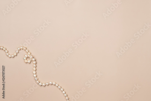 Beige background with pearls. Flat lay, top view. Copy space