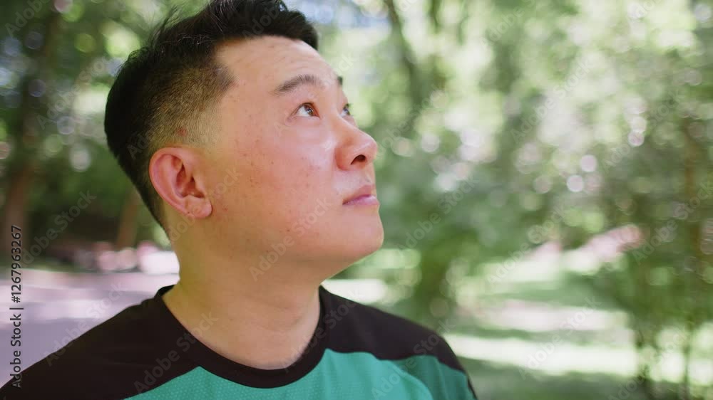 Close-up male portrait outdoors Japanese sport man athlete looking away happy sporty healthy lifestyle posing outside in park. Young guy smiling looking at camera after active exercise fit fitness. Close-up male portrait outdoors Japanese sport man athlete looking away happy sporty healthy lifestyle posing outside in park. Young guy smiling looking at camera after active exercise fit fitness.