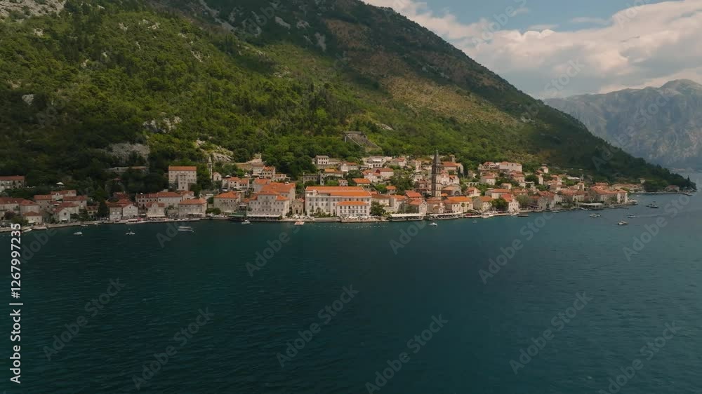 Cinematic drone approach towards the town of Perast on the coast of Kotor Bay, with stone houses, piers, boats, and a church, in Europe Cinematic drone approach towards the town of Perast on the coast of Kotor Bay, with stone houses, piers, boats, and a church, in Europe