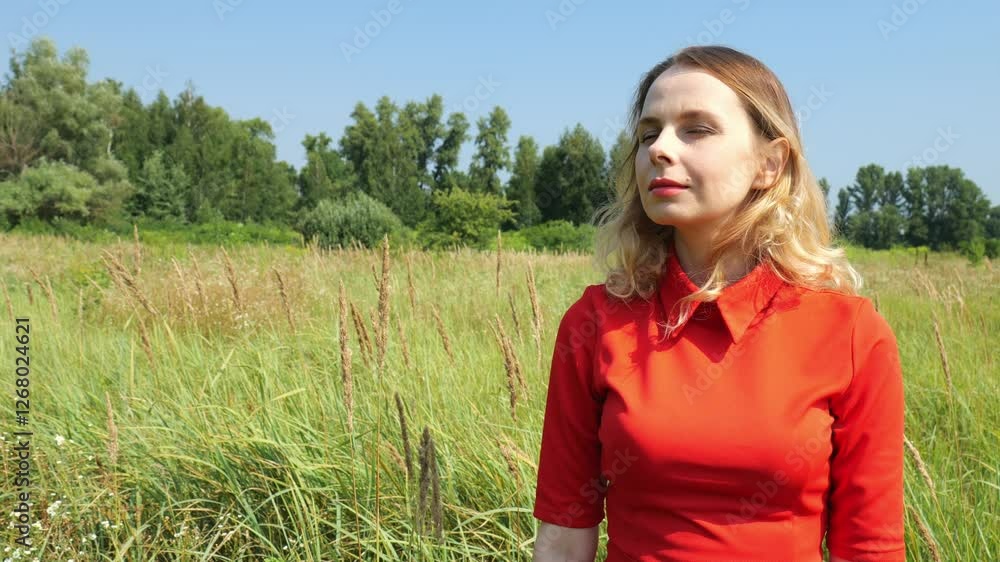 Portrait woman forty year old woman in a field against the background of a forest in the distance. Slow portrait woman. Beautiful woman stands in nature Portrait woman forty year old woman in a field against the background of a forest in the distance. Slow portrait woman. Beautiful woman stands in nature