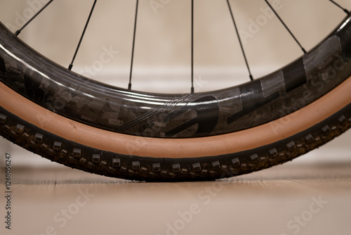 A close up of a carbon rim bike tire. The bike tire is black and brown photo