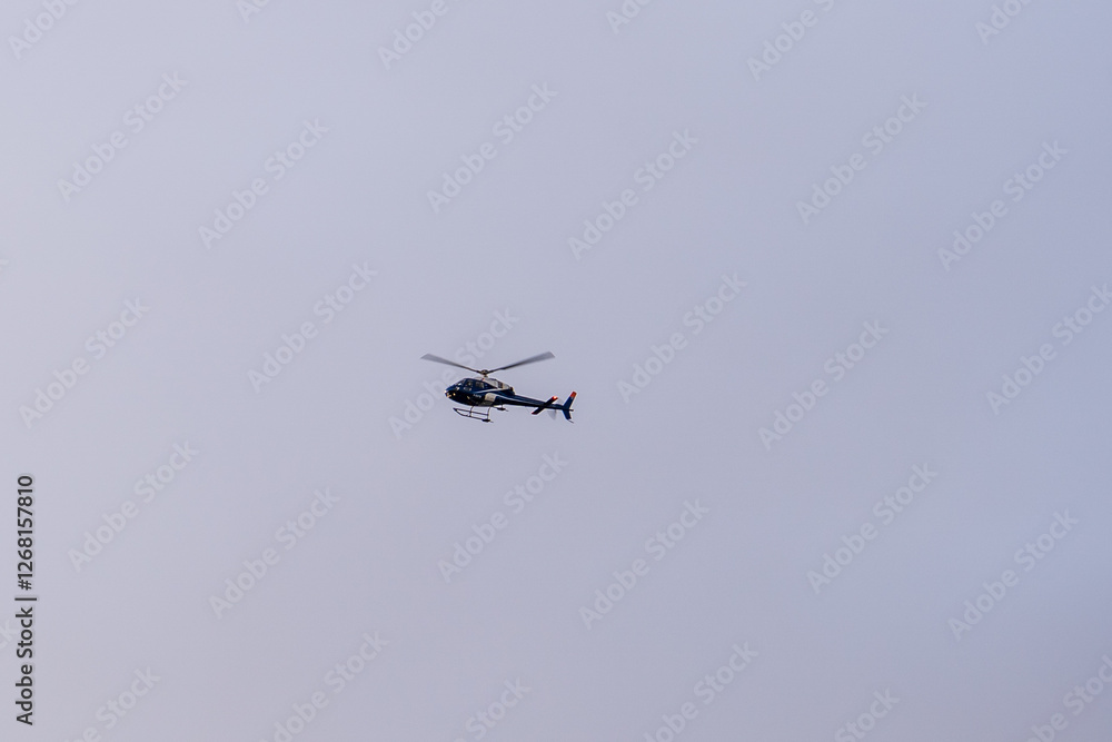A helicopter is flying in the sky. A helicopter during flight. A helicopter is flying in the sky. A helicopter during flight.
