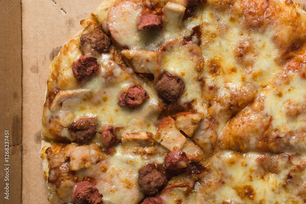 Overhead view of a large pizza in a box, top view of a cheese and sausage pizza in a box Overhead view of a large pizza in a box, top view of a cheese and sausage pizza in a box