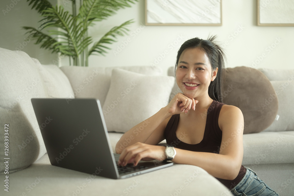 Young adult woman using laptop in bright cozy living room. Young adult woman using laptop in bright cozy living room.