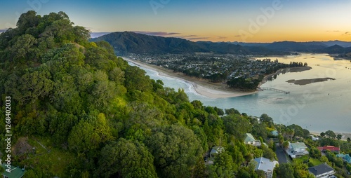 Aerial view of a coastal Tairua and Pauanui town at sunset. Homes nestled amongst lush greenery overlooking a tranquil harbour. Tranquil scene, Coromandel Peninsula, New Zealand photo