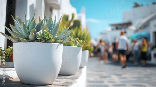 A photo of white flower pots with succulents on the sidewalk in front. The background is white walls and blue sky. People walking around blurred. photo