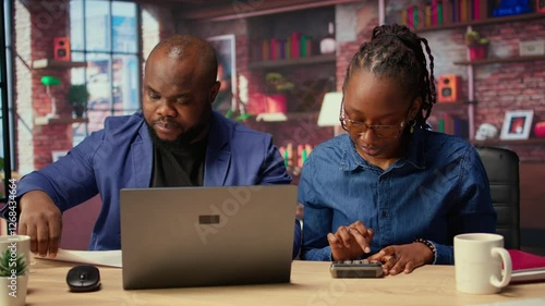 Wallpaper Mural African American couple discusses mortgage and insurance payments at home, using calculator to do their household budgeting and money management. Ensuring a secure financial future. Camera A. Torontodigital.ca