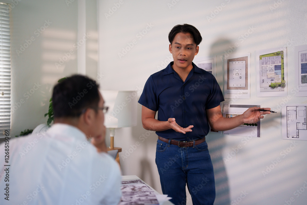 Fototapeta premium A group of engineers reviewing structural designs and material specifications at a meeting table