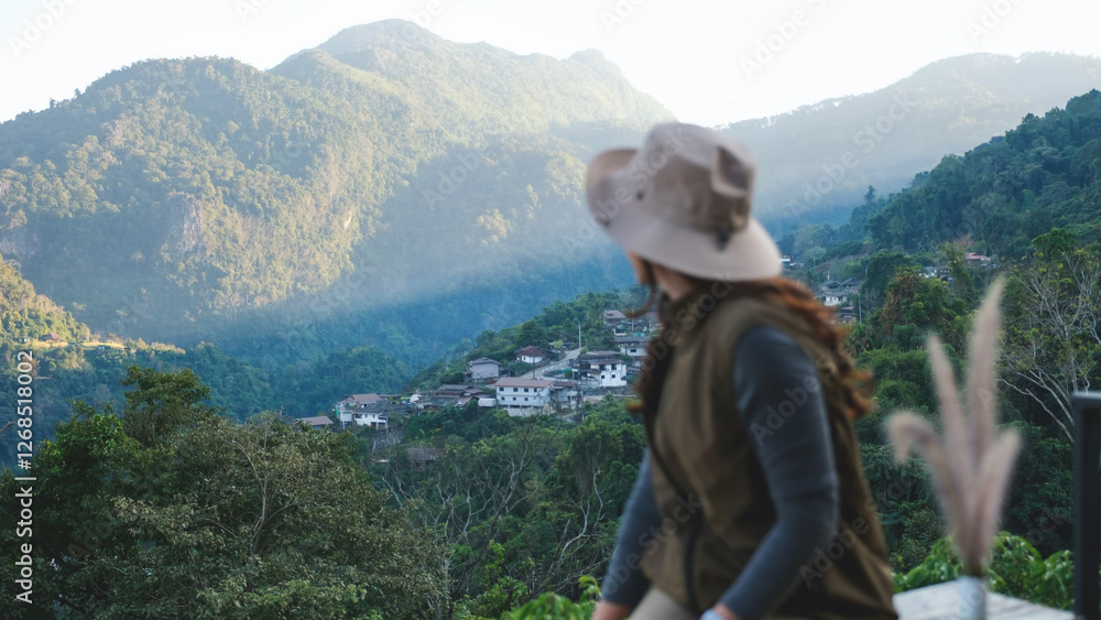 Rear view of a woman looking at a rural village and mountain views Rear view of a woman looking at a rural village and mountain views