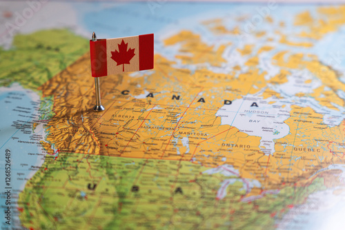 A Canadian flag pinpointed on a map of Canada, symbolizing national identity and geographical location photo