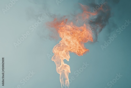 Vivid orange flames and smoke against a light blue background photo