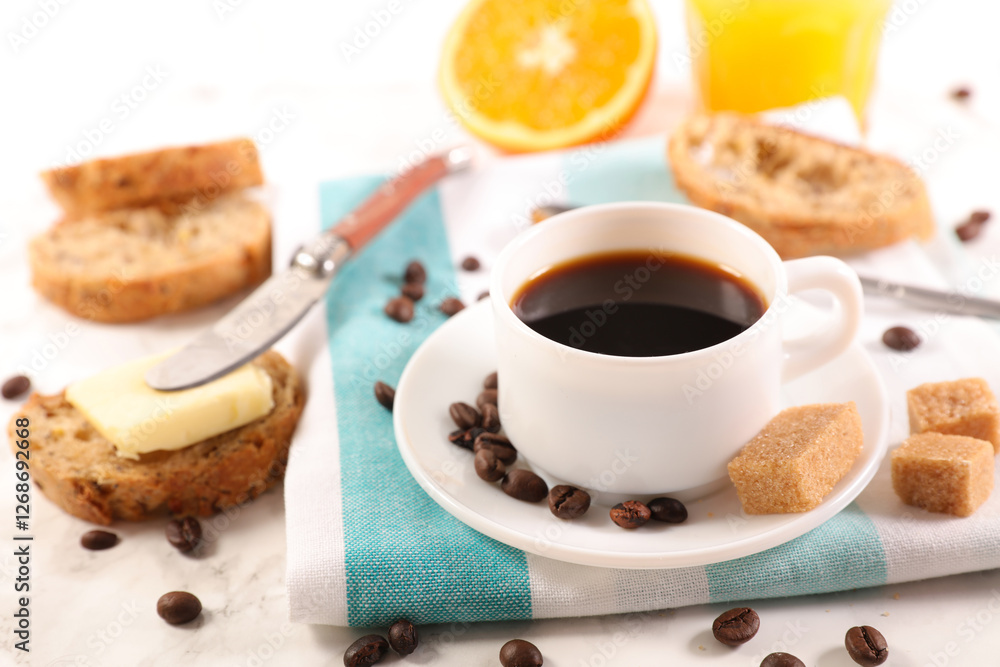 Coffee Cup with Bread, Butter, and Orange Juice on a Table Coffee Cup with Bread, Butter, and Orange Juice on a Table
