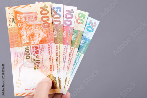 Hong Kong money in the hand on a gray background. photo